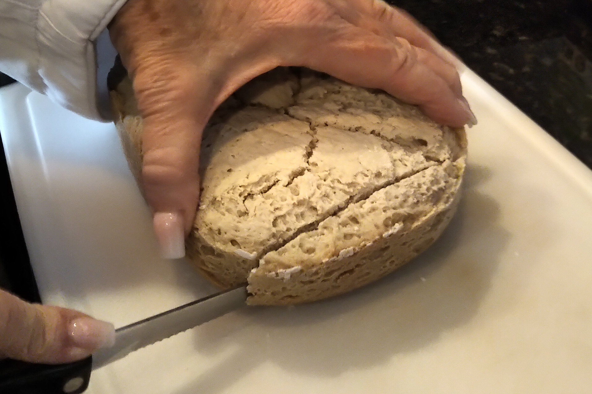 Cutting a slice of gluten free bread