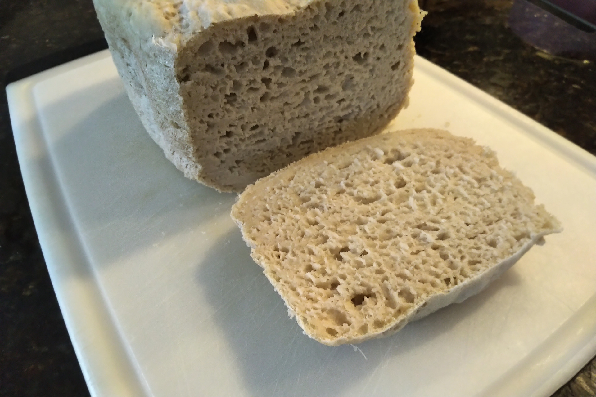 Loaf of gluten free bread with one end cut off to show the inside texture