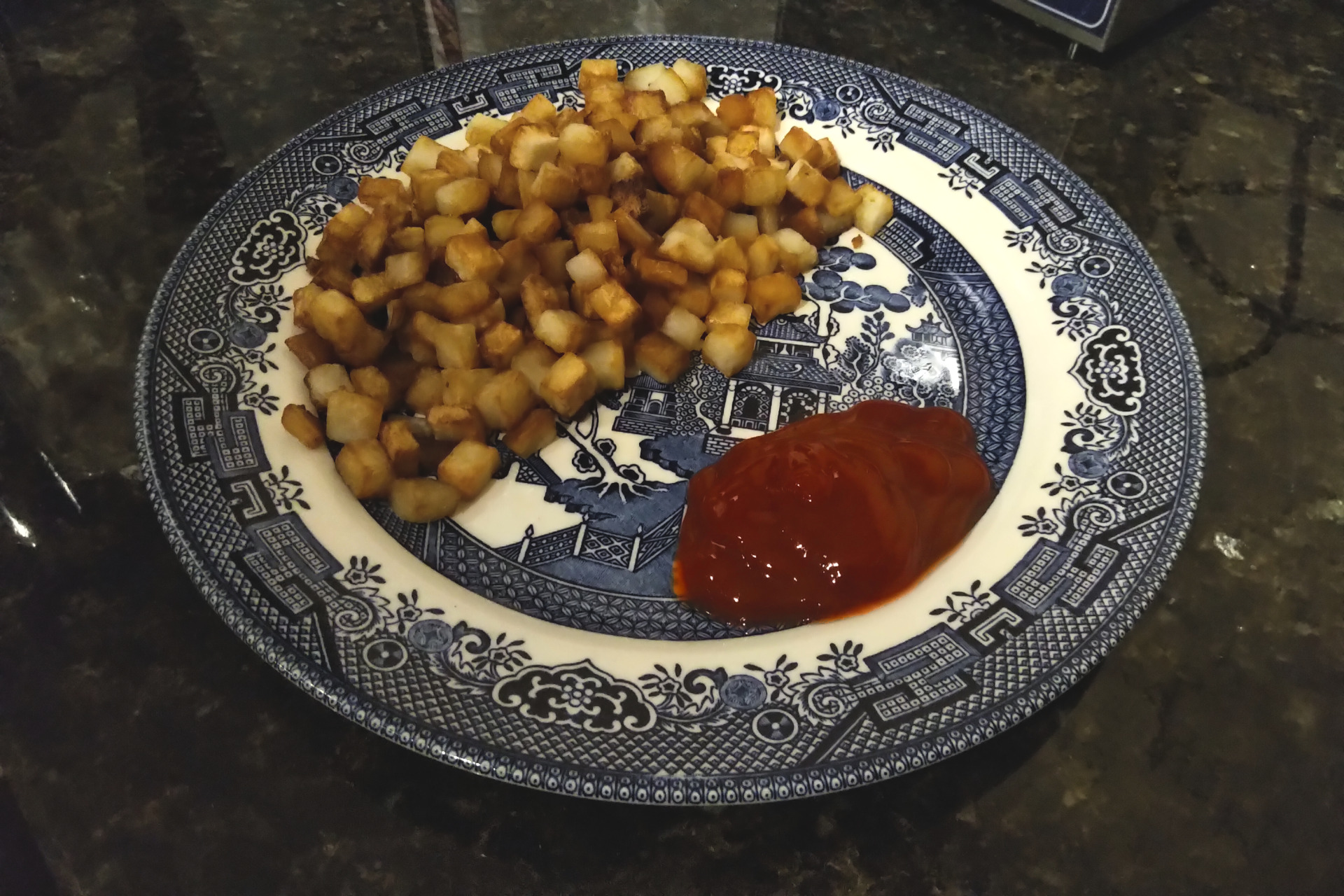 Hash browns on a plate with ketchup
