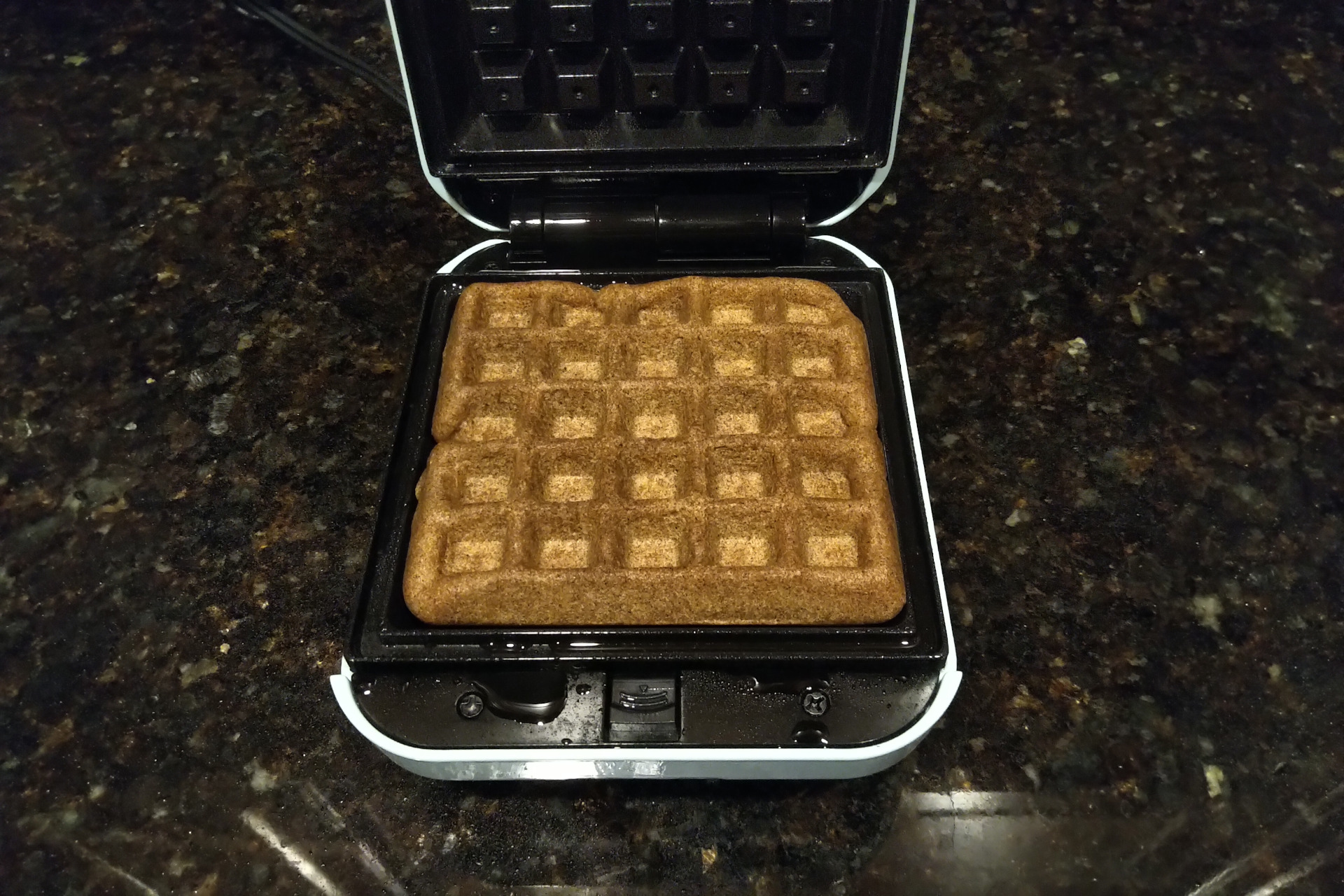 Cooked waffle in a waffle iron