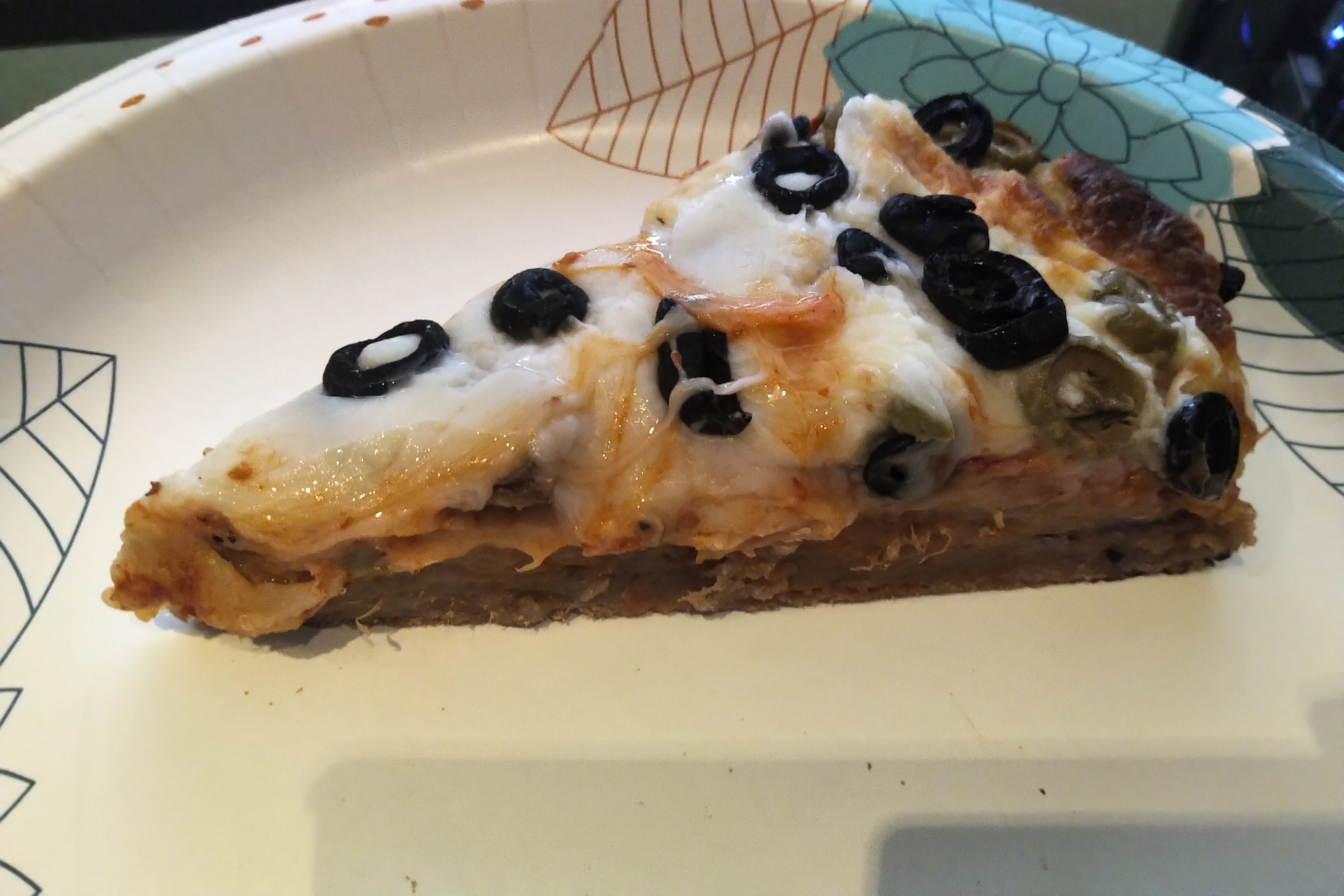 Slice of pizza on a paper plate